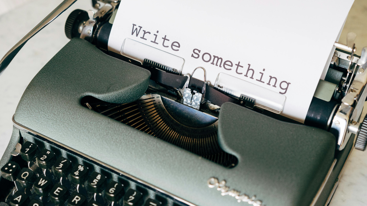 typewriter with a page that says "write something"
